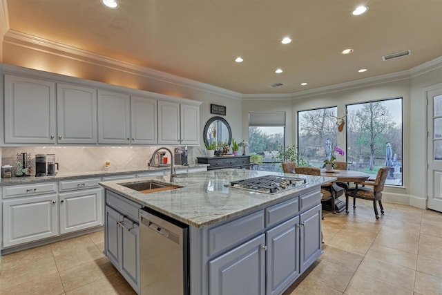 kitchen featuring a kitchen island with sink, gray cabinets, a sink, appliances with stainless steel finishes, and crown molding