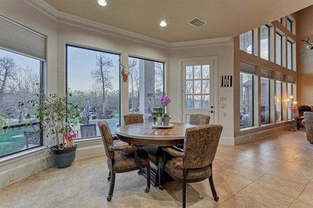 dining room with a wealth of natural light, ornamental molding, and light tile patterned flooring