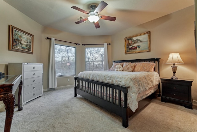 carpeted bedroom with visible vents, baseboards, and a ceiling fan