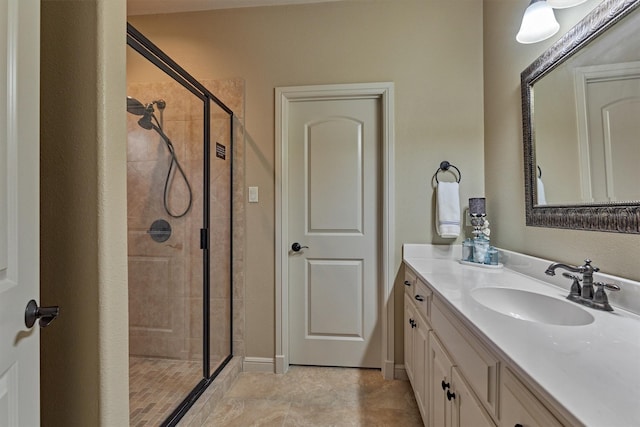 bathroom featuring vanity, a shower stall, and baseboards