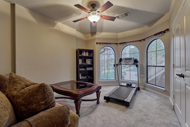 exercise room with visible vents, carpet flooring, baseboards, and a ceiling fan