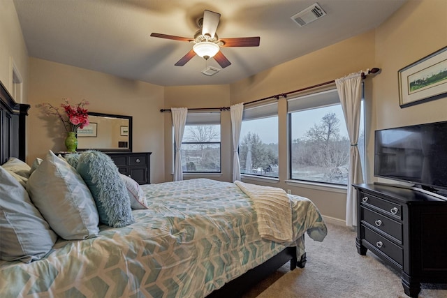 bedroom featuring light carpet, visible vents, baseboards, and a ceiling fan