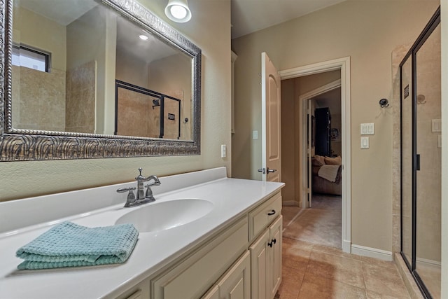 full bathroom with tile patterned floors, baseboards, a stall shower, and vanity