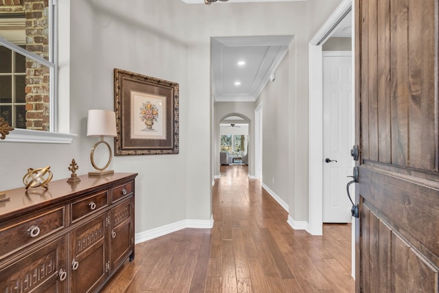 entrance foyer featuring baseboards, ornamental molding, dark wood-style floors, recessed lighting, and arched walkways