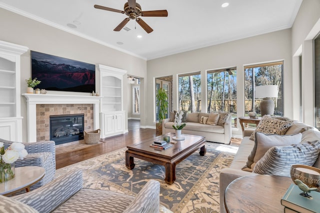 living room featuring ornamental molding, wood finished floors, baseboards, and ceiling fan