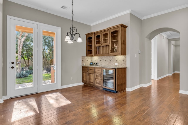 bar featuring beverage cooler, dark wood-style floors, arched walkways, and visible vents