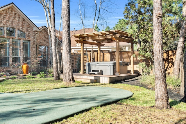 view of yard featuring a hot tub, fence, and a pergola