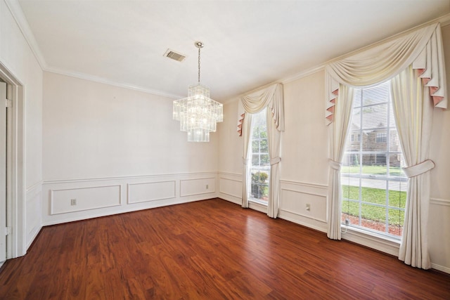 spare room featuring a chandelier, dark wood-style floors, visible vents, and a wealth of natural light