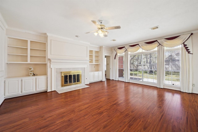 unfurnished living room with a high end fireplace, visible vents, crown molding, ceiling fan, and wood finished floors