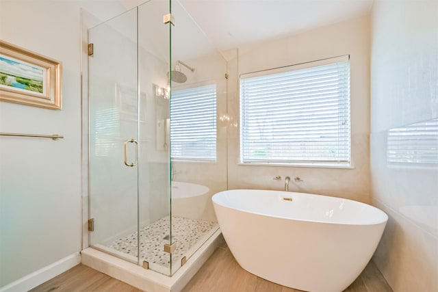 full bath featuring a freestanding tub, wood finished floors, a stall shower, and french doors