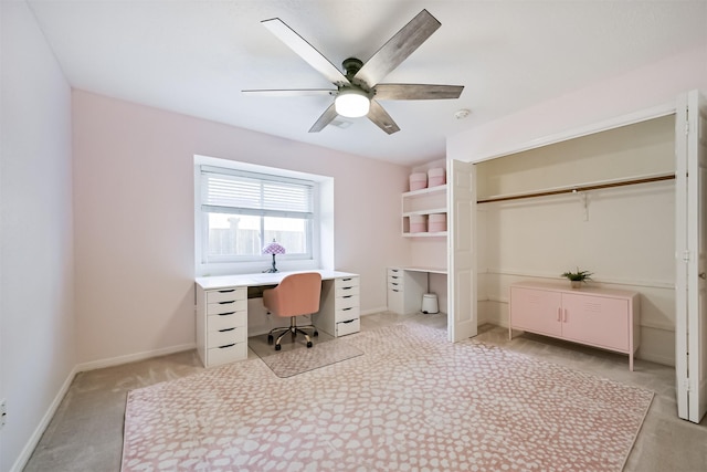 office area featuring baseboards, light carpet, and a ceiling fan