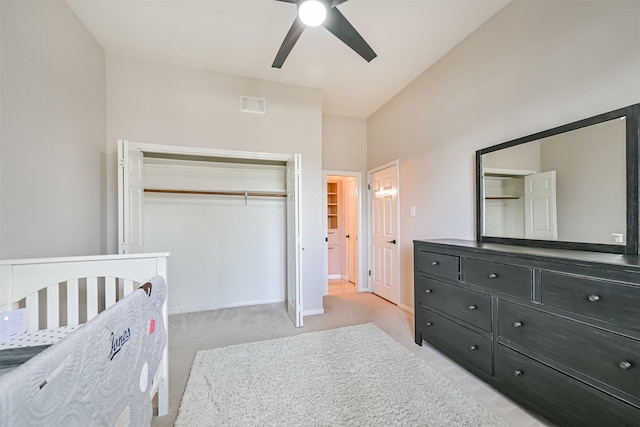 bedroom with a ceiling fan, visible vents, baseboards, a closet, and light colored carpet