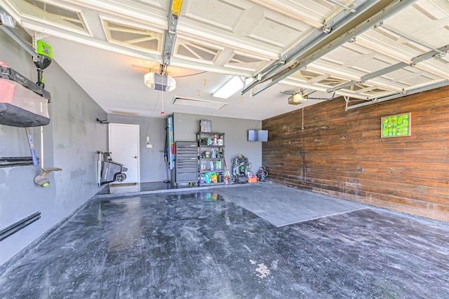 garage featuring wood walls and a garage door opener