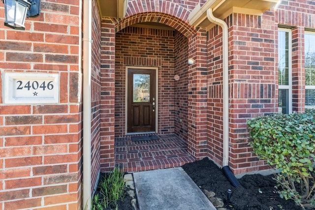 doorway to property featuring brick siding