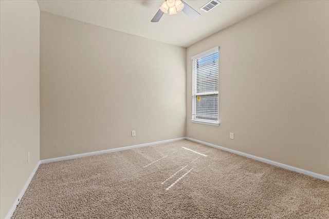 spare room with baseboards, visible vents, carpet floors, and ceiling fan