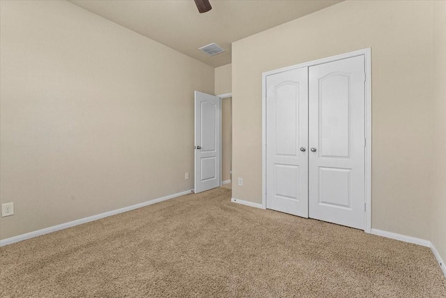 unfurnished bedroom with visible vents, baseboards, light carpet, a closet, and a ceiling fan