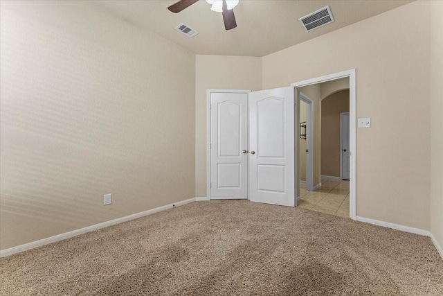 unfurnished bedroom with visible vents, light carpet, and baseboards