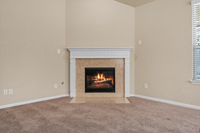 unfurnished living room featuring a wealth of natural light, a fireplace, baseboards, and carpet floors