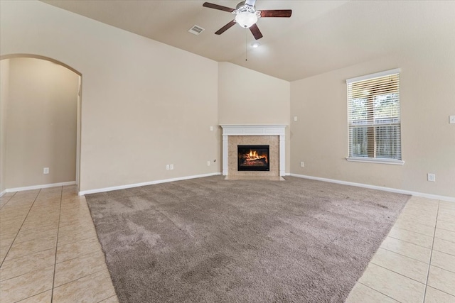 unfurnished living room featuring light tile patterned floors, a ceiling fan, visible vents, arched walkways, and vaulted ceiling