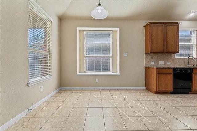 kitchen with brown cabinetry, light tile patterned flooring, a sink, black dishwasher, and tasteful backsplash