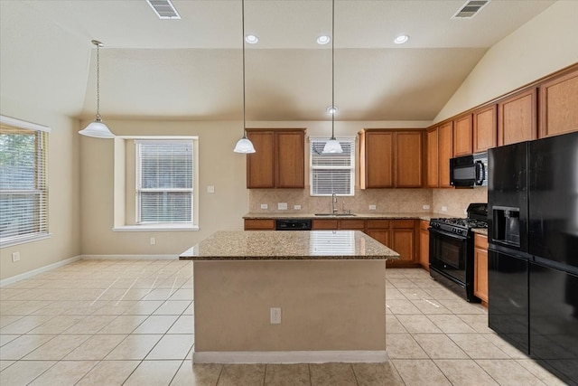 kitchen with light stone counters, light tile patterned floors, visible vents, a sink, and black appliances