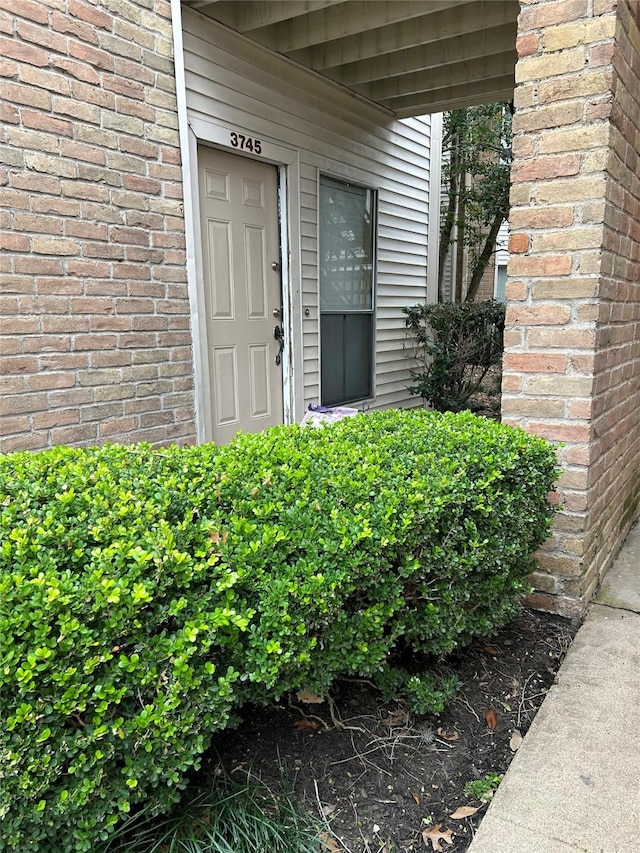 doorway to property featuring brick siding