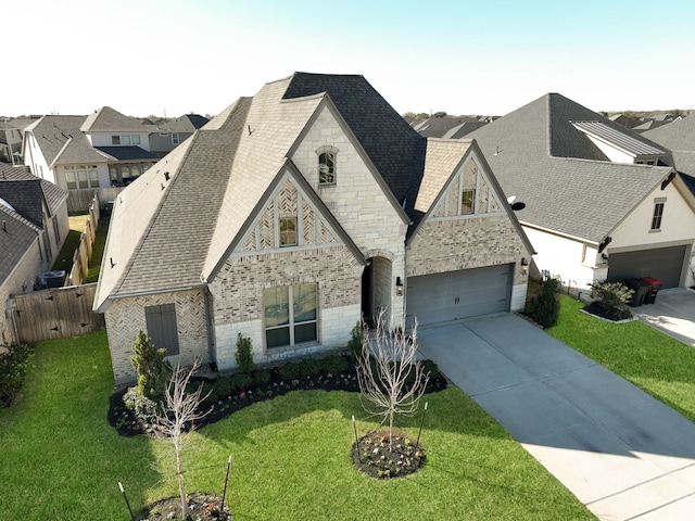 view of front of home with a front lawn, stone siding, roof with shingles, concrete driveway, and brick siding