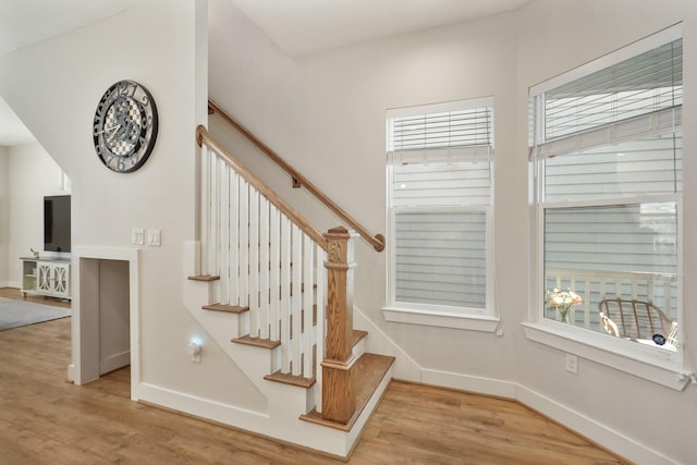 staircase with baseboards and wood finished floors