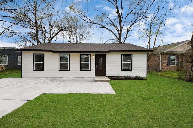 ranch-style home with a front lawn and fence