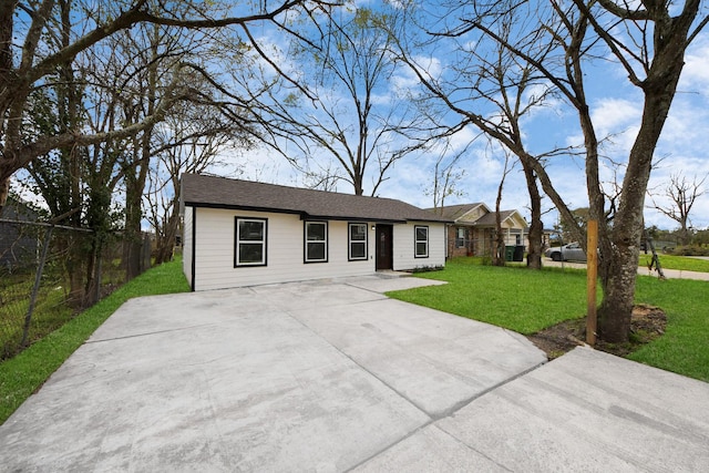 ranch-style home featuring concrete driveway, a front yard, and fence