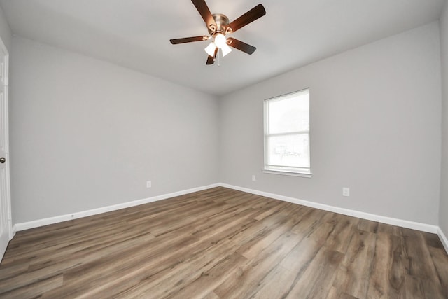 spare room featuring ceiling fan, baseboards, and wood finished floors