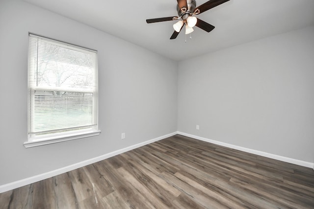 unfurnished room with a ceiling fan, baseboards, and dark wood-style flooring