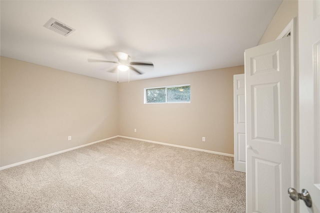 carpeted empty room featuring visible vents, baseboards, and ceiling fan