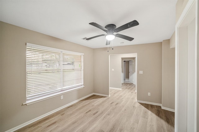 spare room with light wood-type flooring, baseboards, visible vents, and a ceiling fan