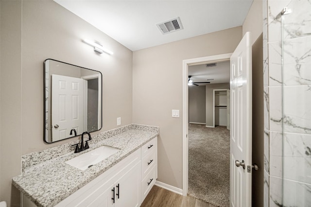 bathroom with visible vents, baseboards, ceiling fan, wood finished floors, and vanity