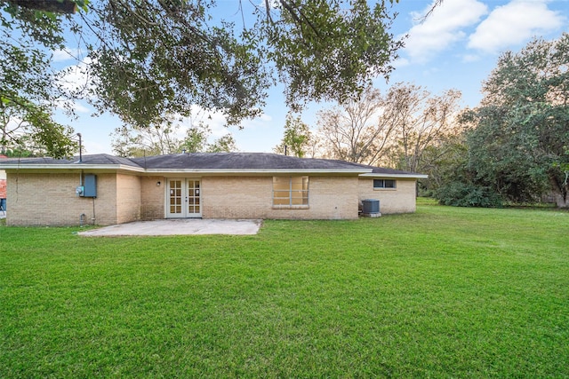 back of property featuring a patio area, a yard, french doors, and brick siding