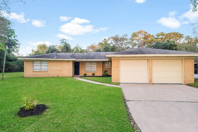 single story home with brick siding, a garage, driveway, and a front lawn