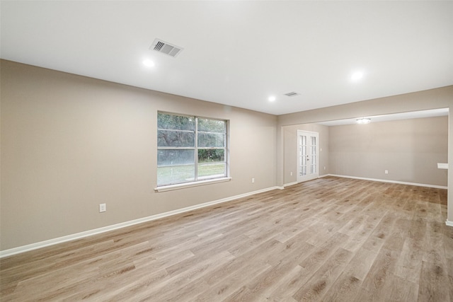 spare room with visible vents, baseboards, and light wood finished floors