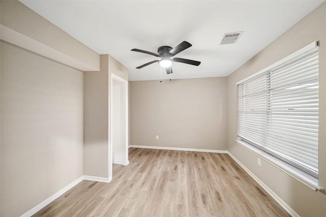 spare room featuring ceiling fan, baseboards, visible vents, and light wood-type flooring