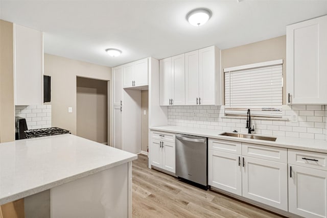 kitchen with stainless steel dishwasher, light wood-style flooring, white cabinets, and a sink