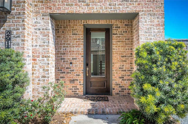 view of exterior entry with brick siding