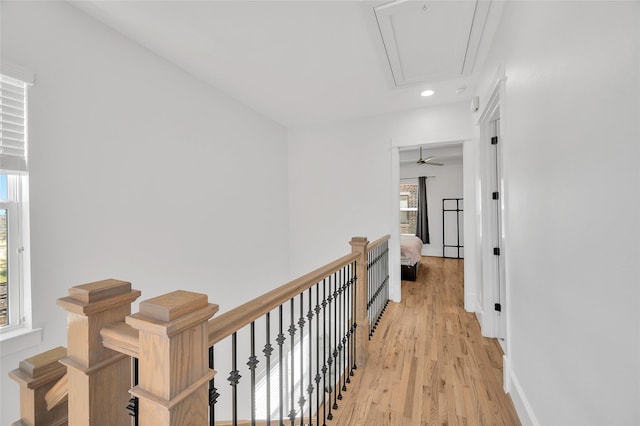 corridor with baseboards, attic access, an upstairs landing, recessed lighting, and light wood-style flooring