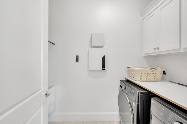 laundry room with baseboards, cabinet space, and washer / clothes dryer