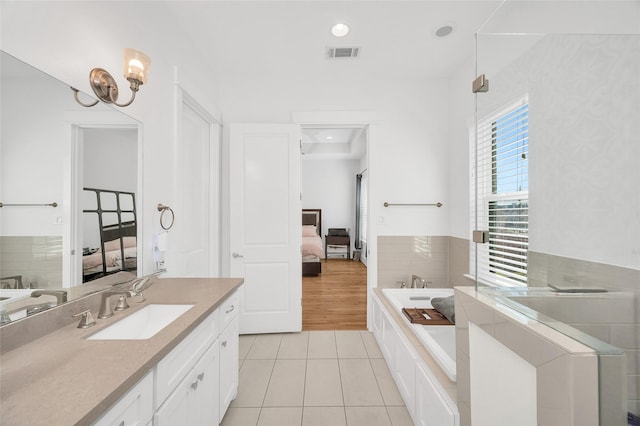 ensuite bathroom with vanity, ensuite bath, visible vents, and tile patterned floors