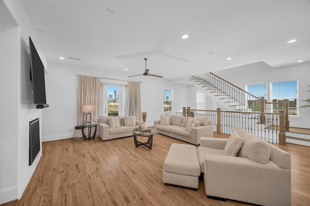 living room featuring recessed lighting, light wood-style floors, a fireplace, baseboards, and ceiling fan