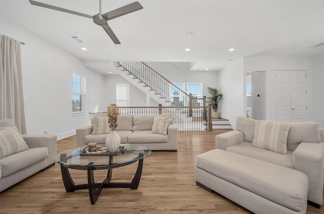 living room featuring a ceiling fan, stairway, recessed lighting, and light wood finished floors