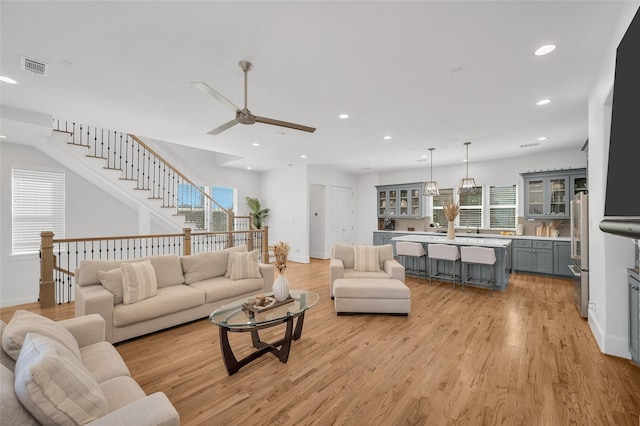 living room with recessed lighting, light wood-style floors, and ceiling fan