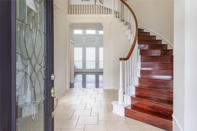 entryway featuring a high ceiling, stairway, and baseboards