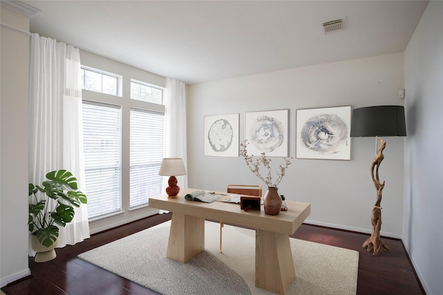 office area with plenty of natural light, wood finished floors, visible vents, and baseboards