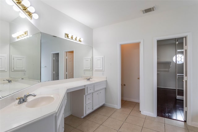 full bath with tile patterned floors, visible vents, double vanity, and a sink